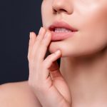 Woman touching lips.
